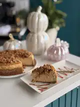 A slice of pumpkin spice cheesecake with streusel crumble and caramel drizzle